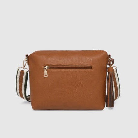 Brown handbag with a strap and tassel on a light gray background