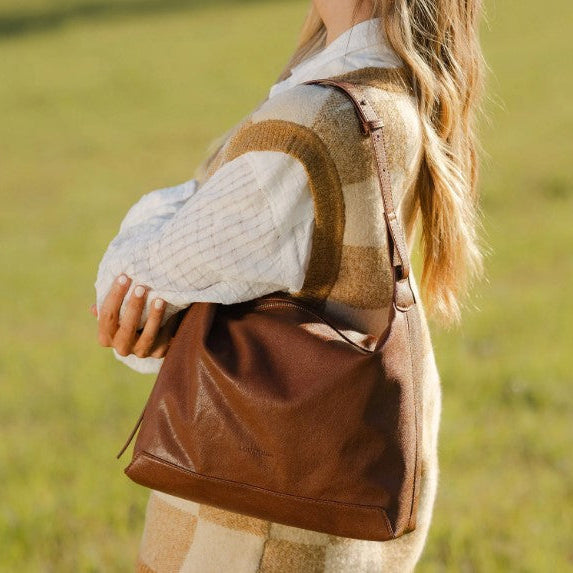 Person holding a brown bag in a field