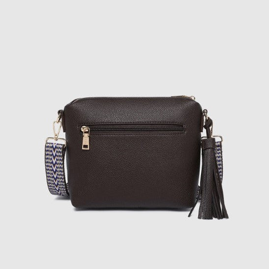 Brown handbag with a tassel on a light gray background