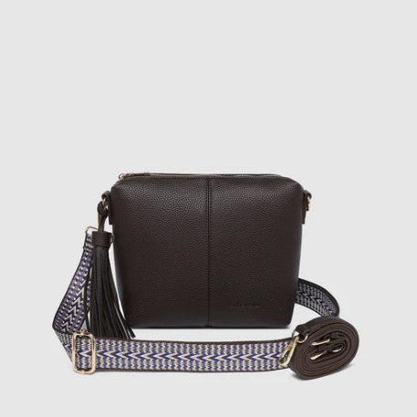 Brown crossbody bag with a patterned strap on a light gray background