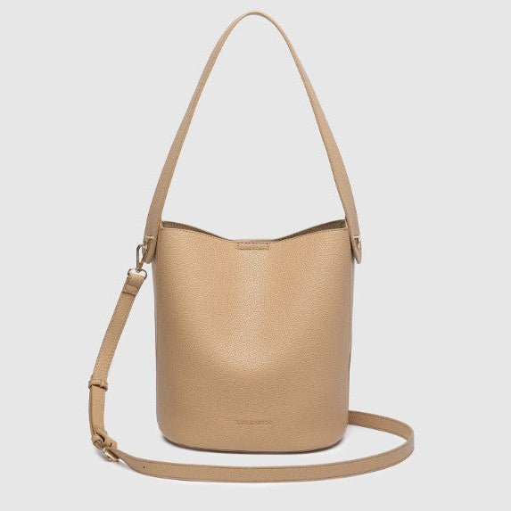 A light tan pebbled leather bucket bag with a matching shoulder strap, displayed against a solid light gray background.