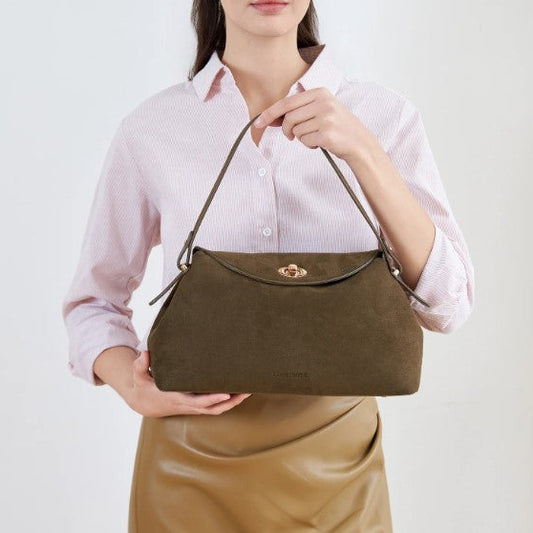 Person holding a brown handbag against a white background