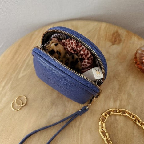 Blue purse with a chain on a wooden surface