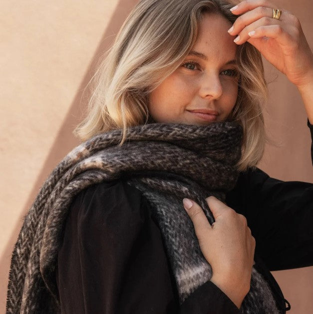 Woman wearing a scarf against a beige background