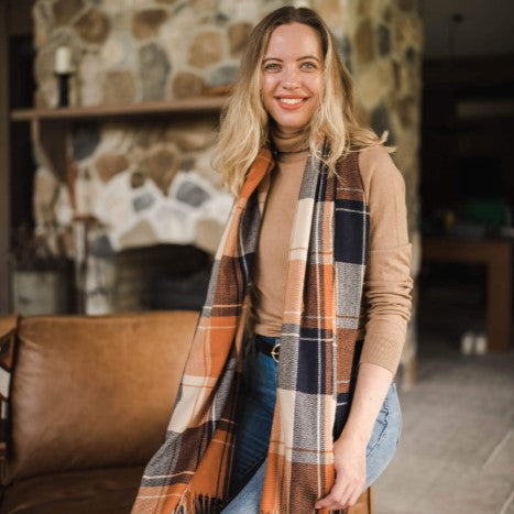 Woman wearing a plaid scarf in a cozy living room setting