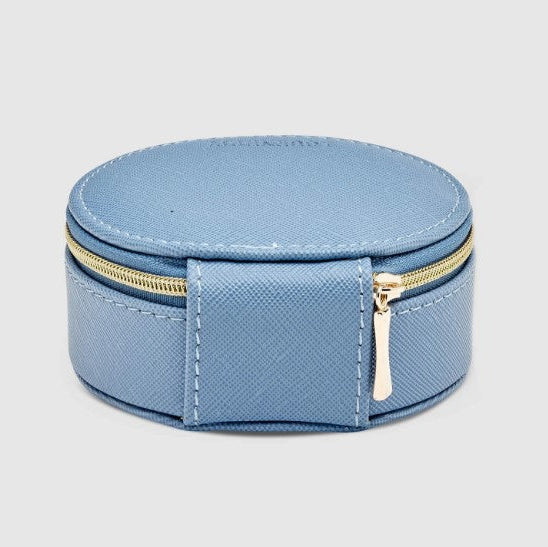 Round blue jewelry box with gold zipper on a light gray background