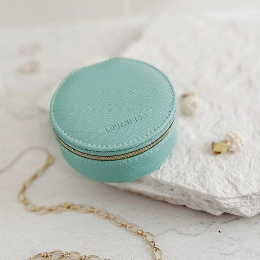 Mint jewelry case with gold zipper on a light background