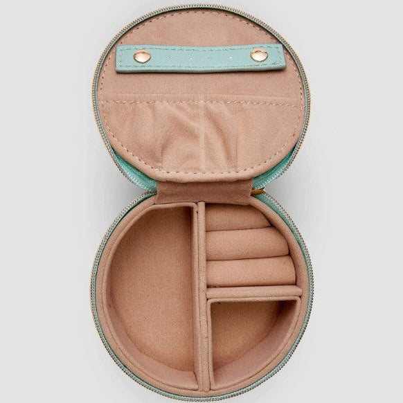 Round jewelry case with beige interior and teal exterior on a light gray background