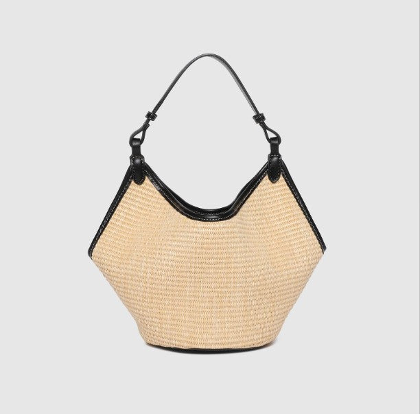 Beige straw handbag with black accents on a light gray background