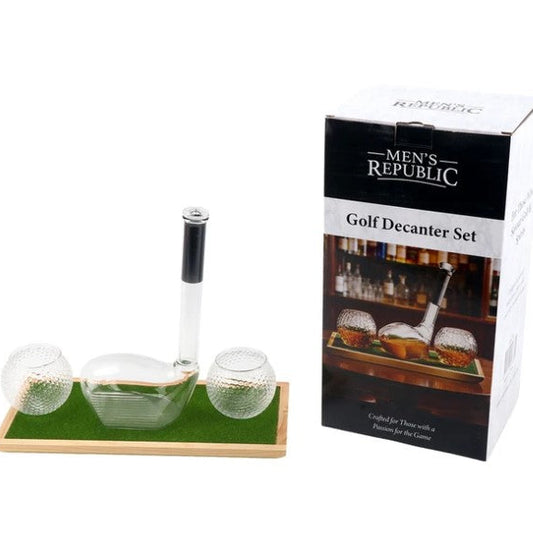 Men's Republic Golf Decanter Set with a clear glass decanter, two textured glass golf balls, and a clear stand on a green mat, shown next to its retail packaging box.