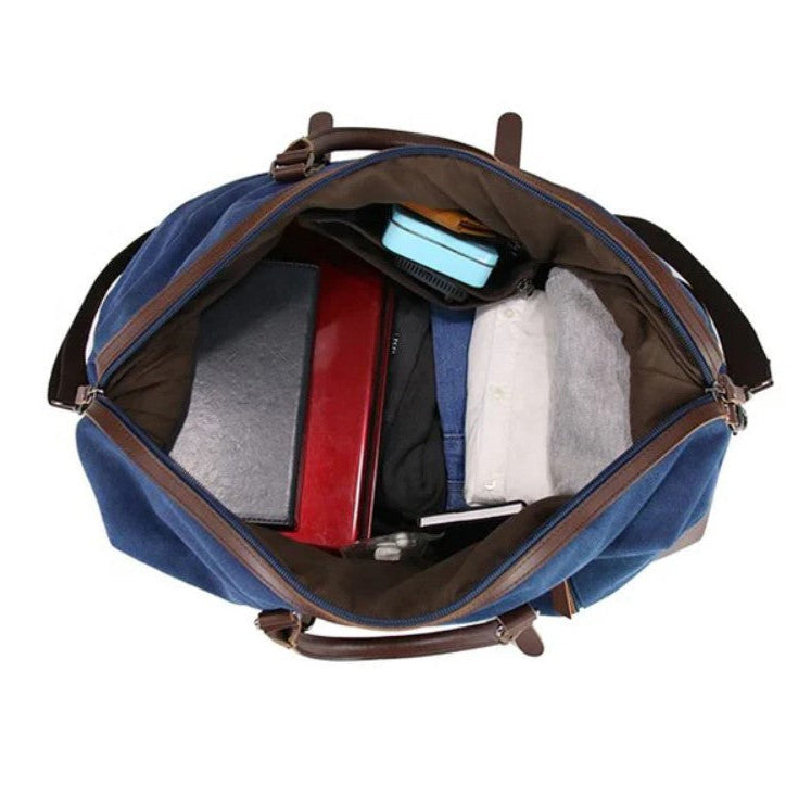 Blue duffel bag with brown handles and trim, open to reveal various items on a white background.