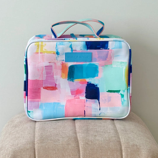 Colorful abstract patterned hanging toiletry bag on a beige surface