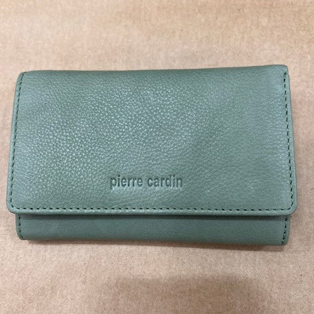 Green wallet with 'pierre cardin' branding on a beige background