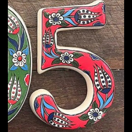 Decorative number '5' with floral patterns on a wooden surface