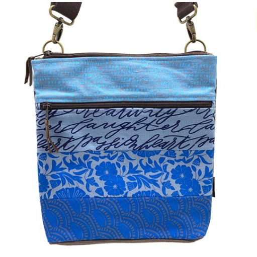 Blue patterned crossbody bag with floral and abstract designs on a white background