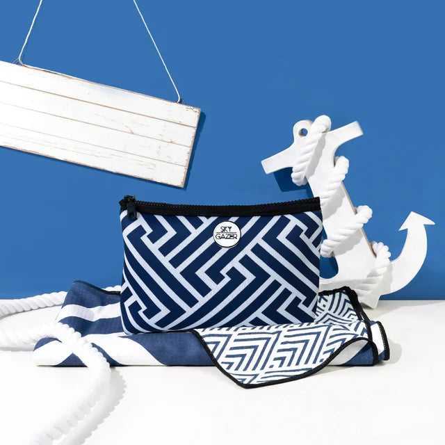 Nautical-themed product with blue and white patterned bag and towel against a blue background with an anchor.