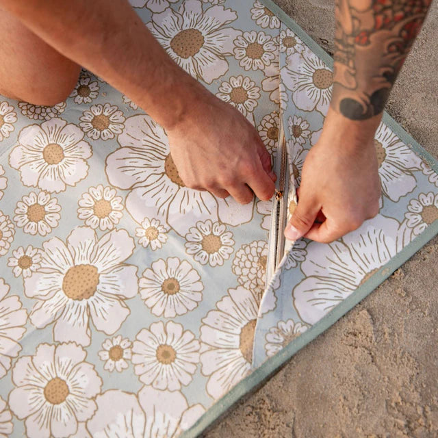 Person showing hidden pocket on picnic mat