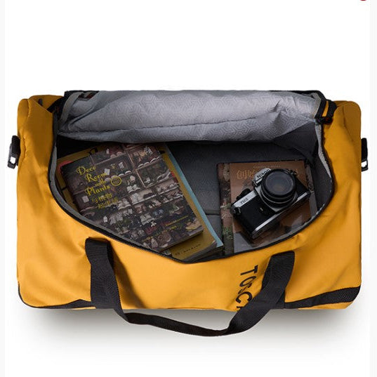 Yellow duffel bag with books and a camera inside on a white background