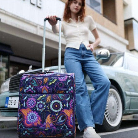 Woman pulling a colorful suitcase in an urban setting