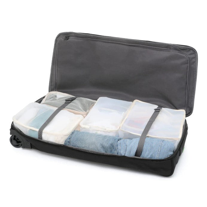 Black suitcase with clothes organized in clear bags on a white background
