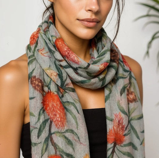 Woman wearing a floral patterned scarf with red flowers and green leaves.