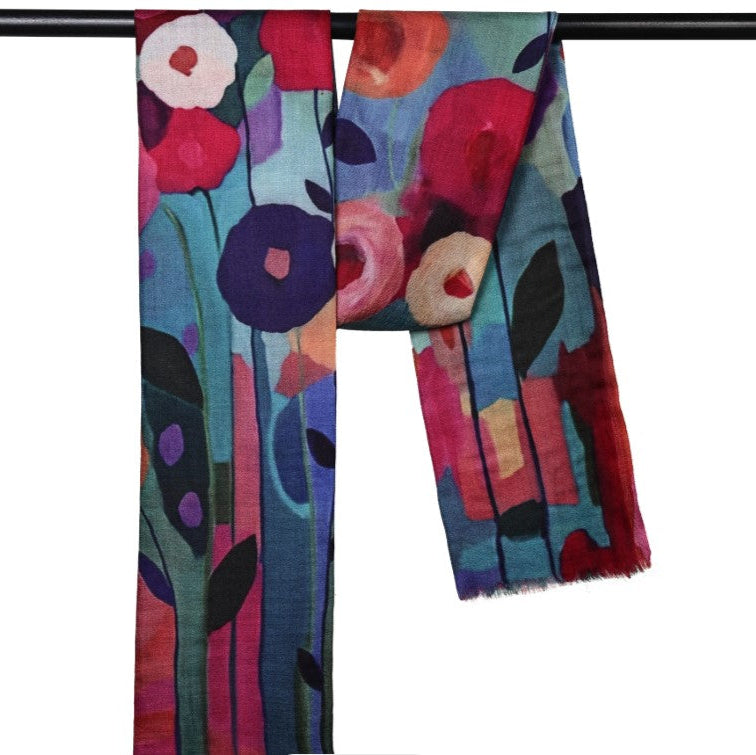 Colorful floral-patterned scarf on a black rod against a white background
